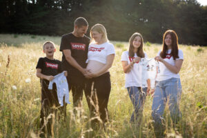Spaß beim Babybauchshooting in der Wiese - Patchworkfamilie
