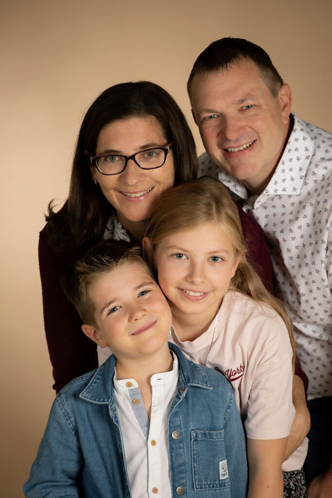 familienportrait im studio eltern mit bub und mädchen kuscheln ganz nah zusammen